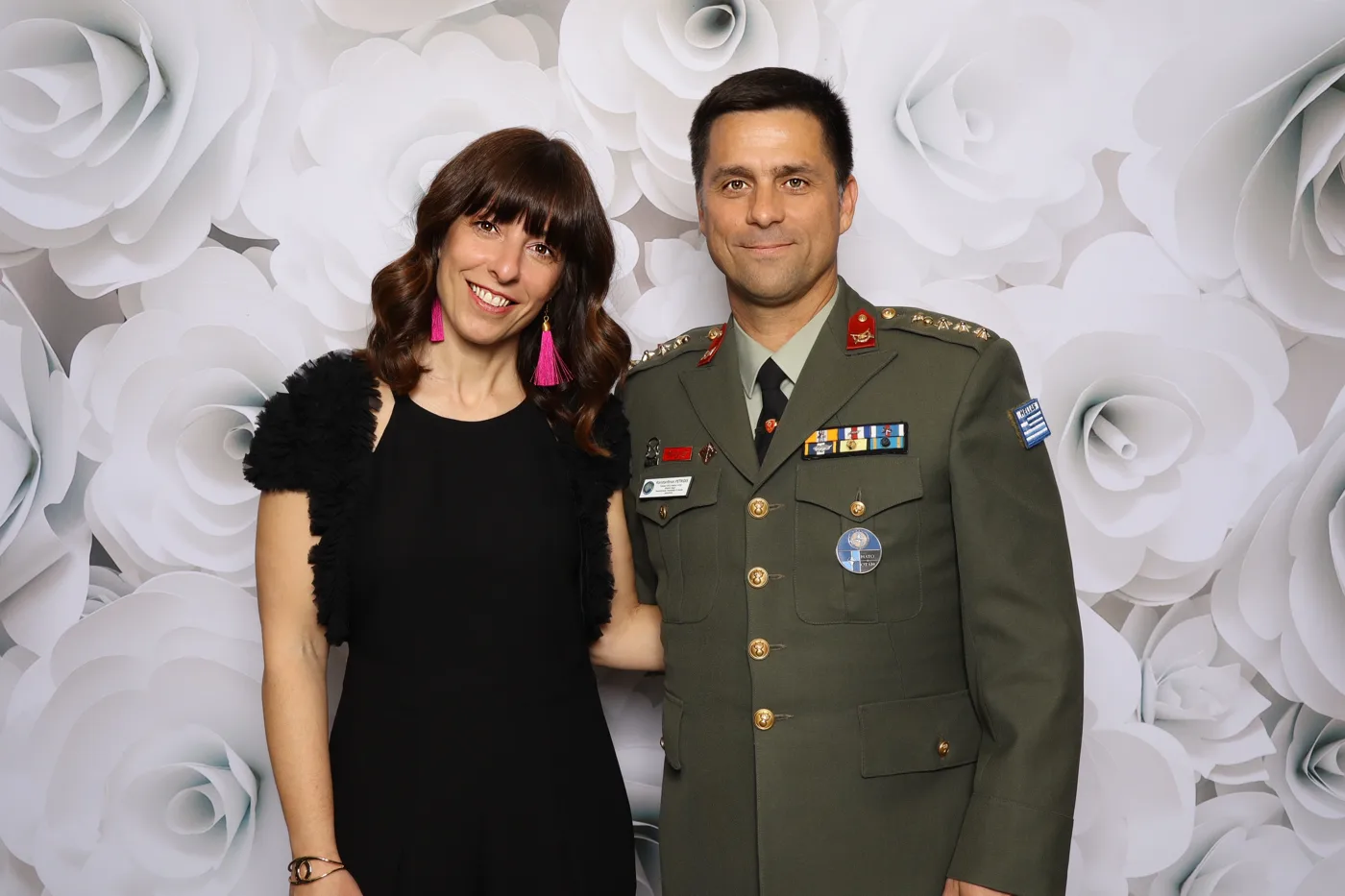 Officer in dress uniform with guest at the Officers Mess Garden Gala photo booth, white rose backdrop